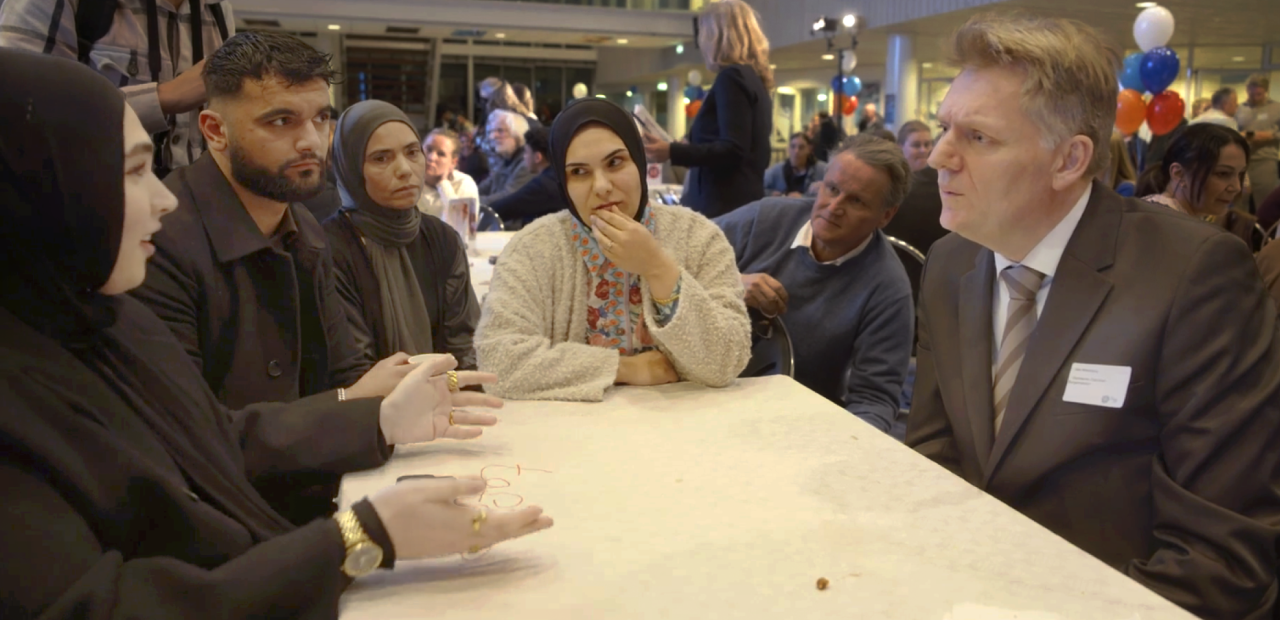 Burgemeester Jan Hamming in gesprek met bewoners van de wijk Poelenburg. 