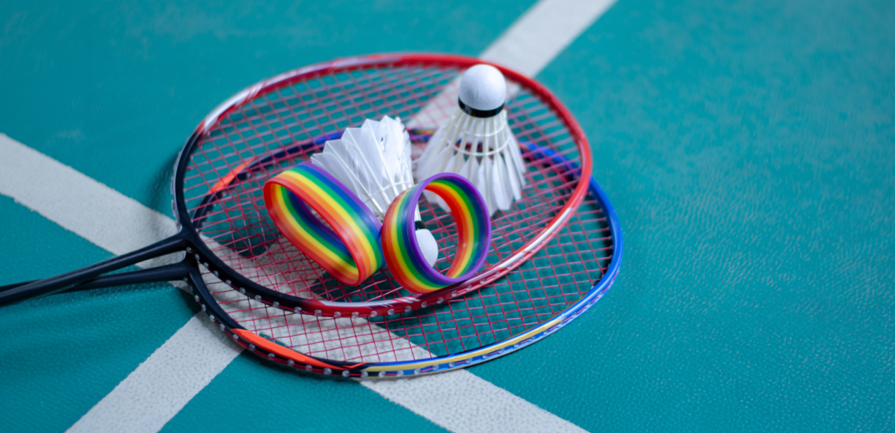 Foto van twee badmintonrackets met twee shuttles en twee armbandjes in regenboogkleuren 