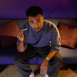 Benji zit in de studio en heeft een niet-aangestoken sigaret in zijn hand.