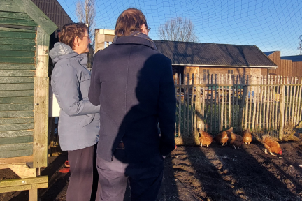 Verslaggever Ids Nicolai interviewt regiodirecteur Esmé Wiegman van het Leger des Heils. Ze staan in de kippenren van een Beschermd Wonen locatie.