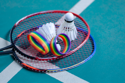 Foto van twee badmintonrackets met twee shuttles en twee armbandjes in regenboogkleuren 