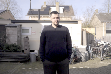 Dani staat voor zijn huis 