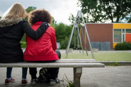 Kind op bankje op schoolplein / ANP