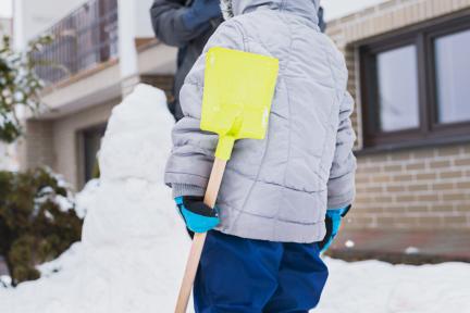 Kindje speelt in de sneeuw / Dreamstime