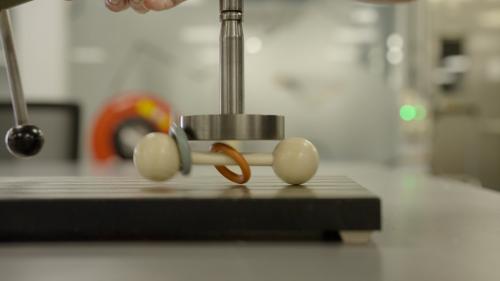 Stootproef waarbij het gewicht op een rammelaar valt.  