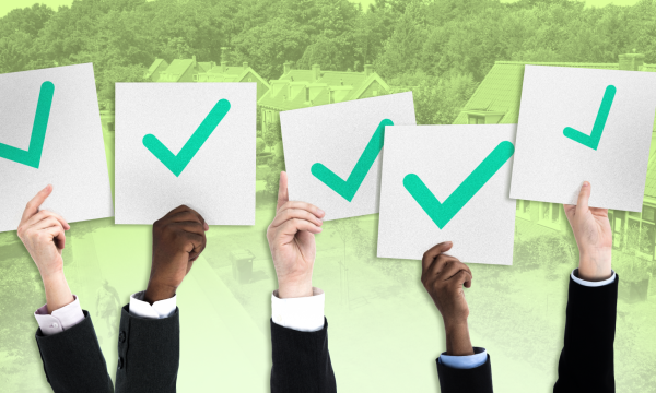 Burgers houden borden omhoog met daarop groene vinkjes