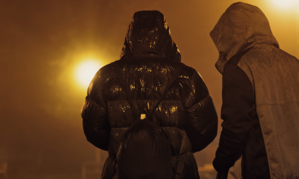 Twee jongeren die 's avonds op straat lopen