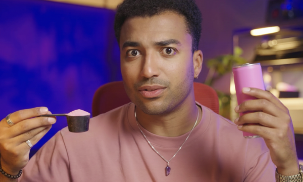 Pointer Checkt-presentator Benji houdt een maatschep met pre-workout en een blikje energydrank vast