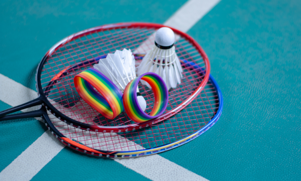 Foto van twee badmintonrackets met twee shuttles en twee armbandjes in regenboogkleuren 