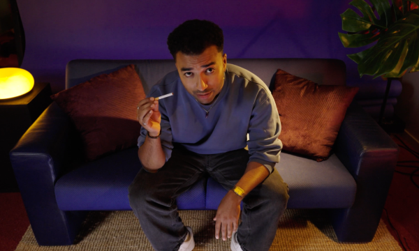Benji zit in de studio en heeft een niet-aangestoken sigaret in zijn hand.