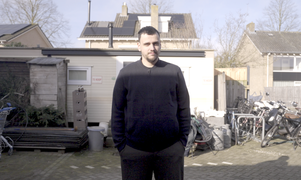 Dani staat voor zijn huis 